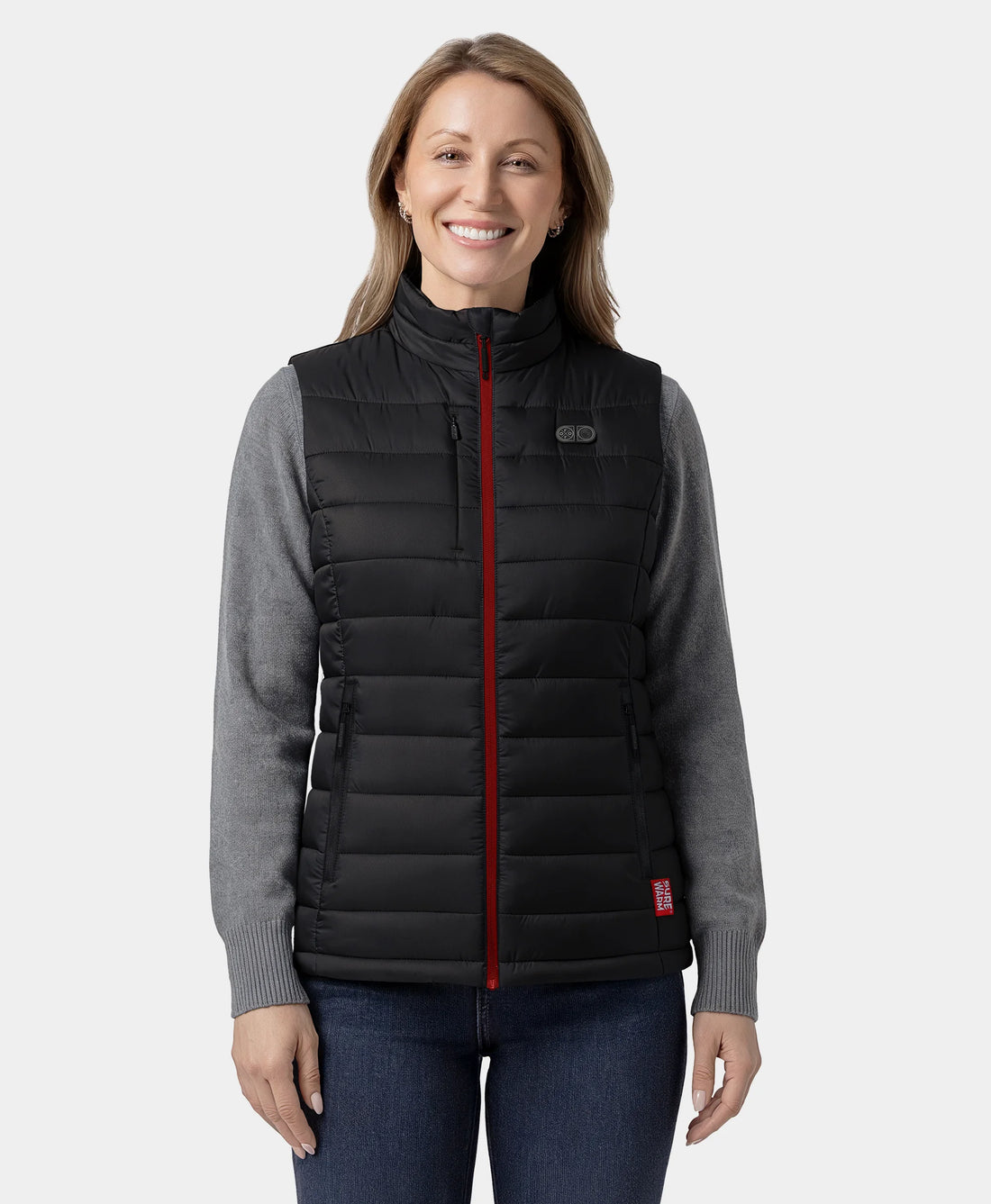 Woman wearing a black puffer vest with a red zipper on a white background
